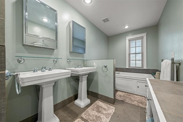 bathroom with a garden tub, baseboards, visible vents, and recessed lighting