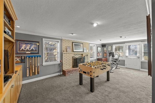 rec room featuring carpet, a fireplace, baseboards, and crown molding