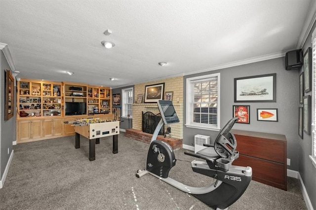 playroom with a fireplace, crown molding, carpet flooring, a textured ceiling, and baseboards