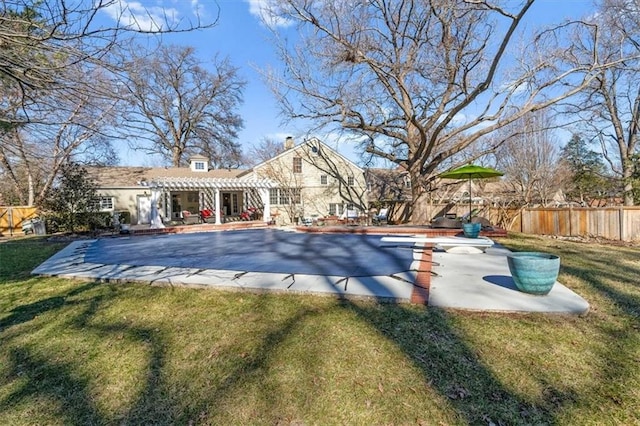 view of pool featuring a lawn, a patio area, fence, a pergola, and a diving board