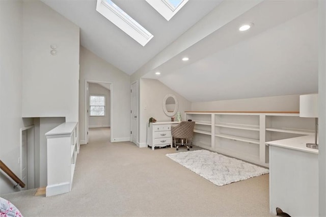 interior space with recessed lighting, vaulted ceiling with skylight, baseboards, and light colored carpet