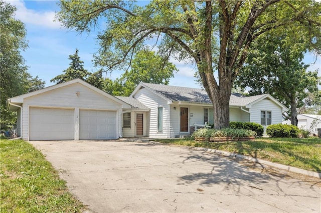 ranch-style house featuring an attached garage, a front lawn, and concrete driveway