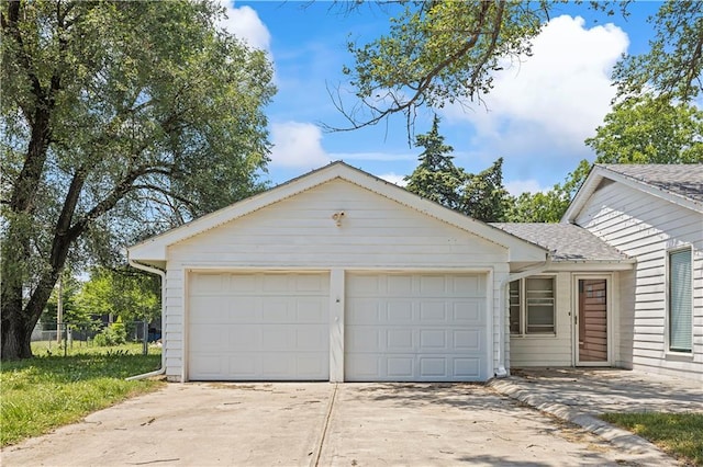 view of front of property with a garage, driveway, a shingled roof, and fence