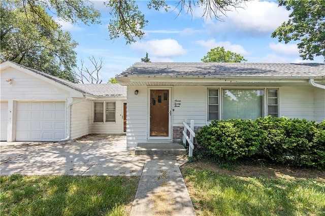 single story home with a garage and a shingled roof