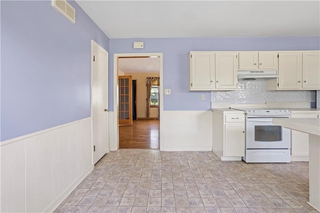 kitchen with electric stove, light countertops, visible vents, and under cabinet range hood