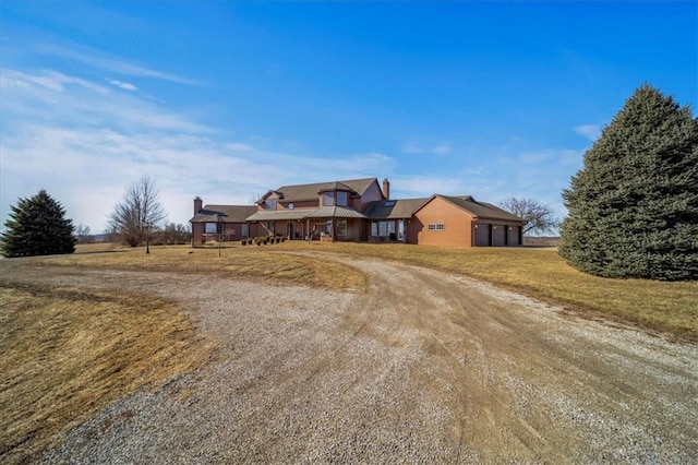 single story home with a front lawn, an attached garage, and dirt driveway