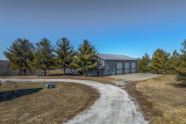 view of front facade with a garage, a front lawn, and dirt driveway