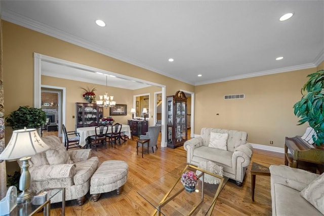 living room with light wood-type flooring, visible vents, a chandelier, and crown molding