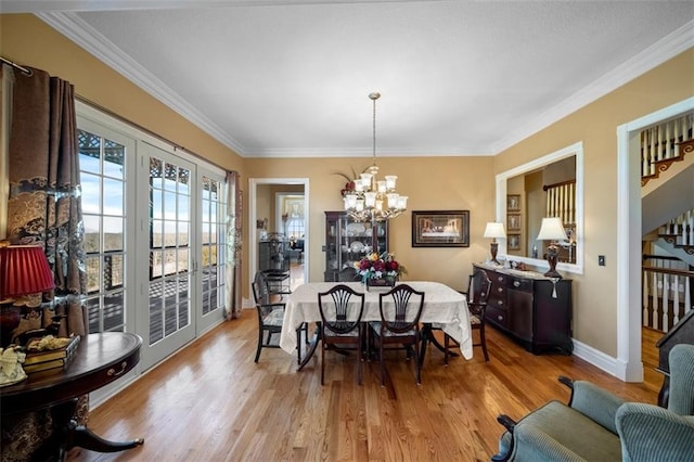 dining space with stairway, ornamental molding, light wood finished floors, and a chandelier