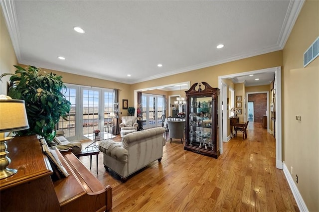 living area featuring crown molding, light wood-style floors, baseboards, and french doors