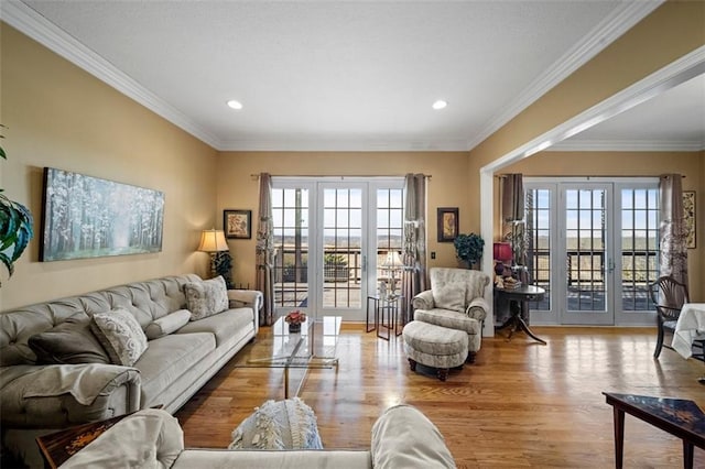 living room with wood finished floors, crown molding, recessed lighting, and french doors