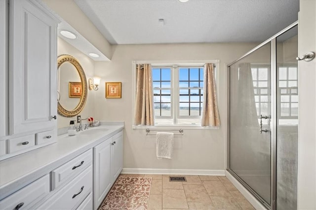 full bath featuring a shower with door, visible vents, baseboards, and vanity