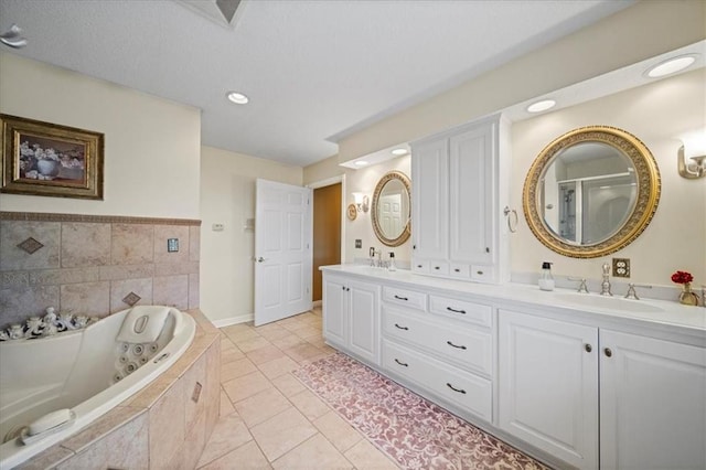 full bath with a tub with jets, baseboards, double vanity, a sink, and tile patterned floors