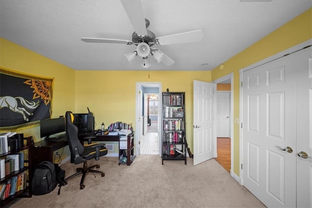 office featuring a ceiling fan, carpet floors, and a textured ceiling