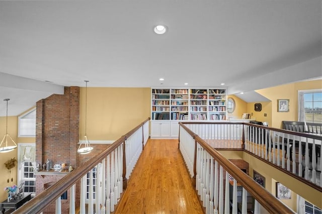 hallway with recessed lighting, light wood-style flooring, built in shelves, and vaulted ceiling with beams