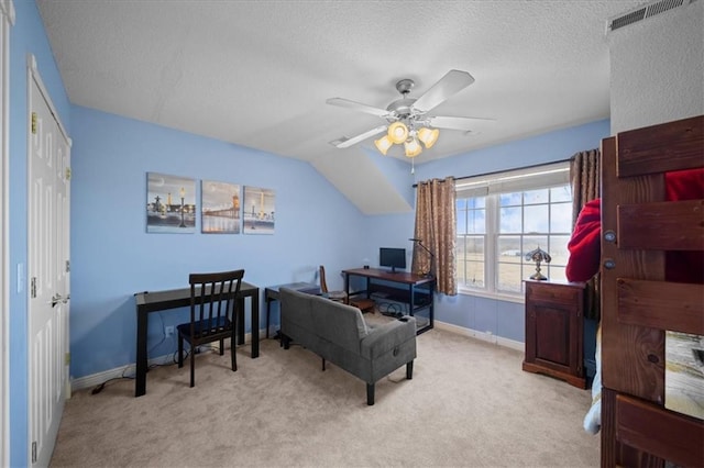 carpeted office space featuring baseboards, visible vents, a textured ceiling, and a ceiling fan