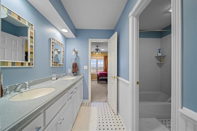 ensuite bathroom featuring bathtub / shower combination, double vanity, connected bathroom, and a sink