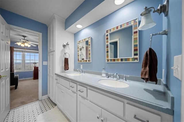 full bathroom with a sink, baseboards, ceiling fan, and double vanity