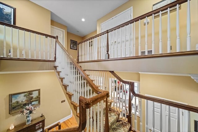 stairway with wood finished floors, recessed lighting, and baseboards