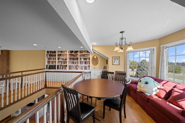 dining space featuring recessed lighting, a textured ceiling, an inviting chandelier, and wood finished floors