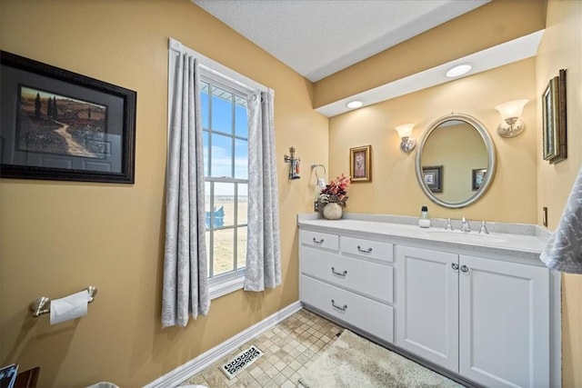 bathroom with visible vents, baseboards, vanity, tile patterned floors, and a textured ceiling