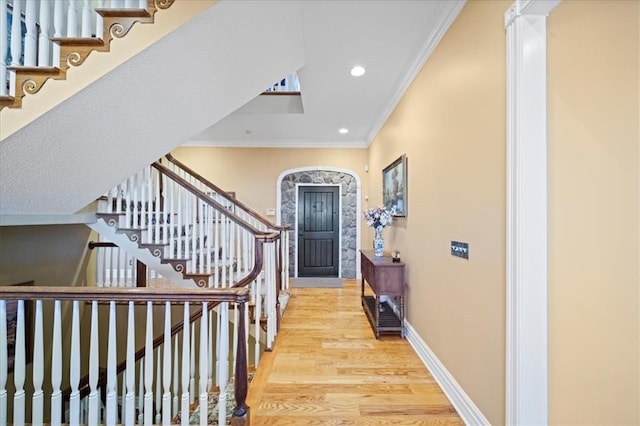 foyer featuring wood finished floors, recessed lighting, stairway, crown molding, and baseboards