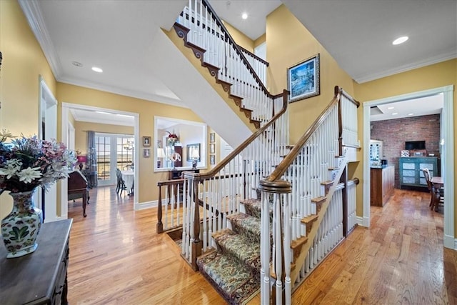 stairway featuring recessed lighting, wood finished floors, baseboards, and ornamental molding