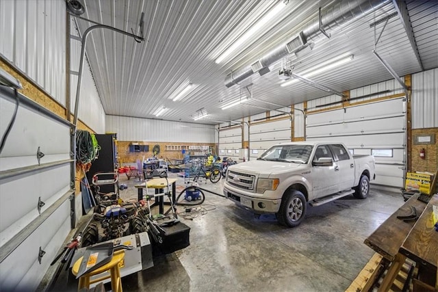 garage with a garage door opener and metal wall