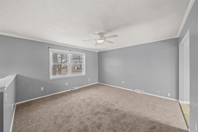 empty room with ornamental molding, visible vents, and carpet floors