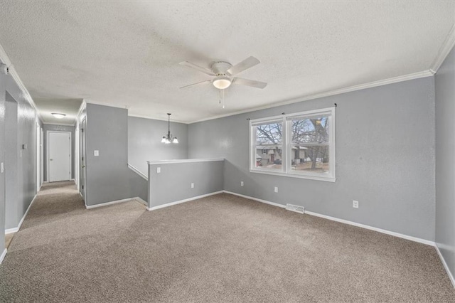 carpeted empty room with a textured ceiling, ceiling fan with notable chandelier, visible vents, baseboards, and crown molding