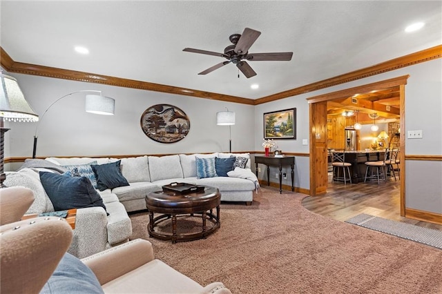 carpeted living room featuring ceiling fan, crown molding, and recessed lighting