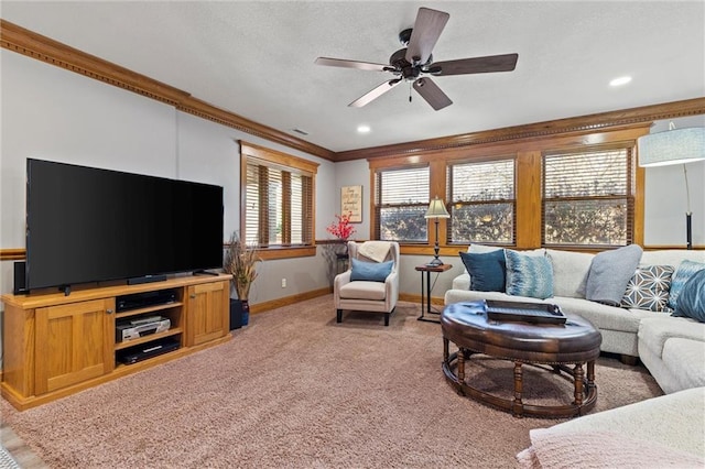 living room with crown molding, light colored carpet, a ceiling fan, a textured ceiling, and baseboards