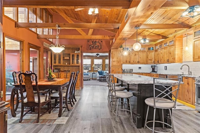 kitchen featuring light wood-style flooring, a kitchen island, a ceiling fan, and decorative backsplash