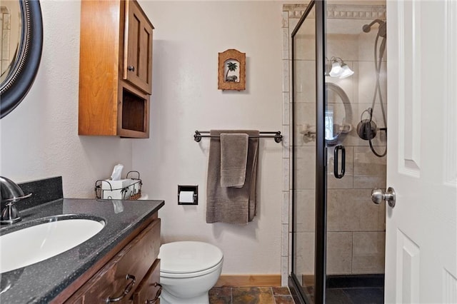 full bath featuring a stall shower, vanity, and toilet