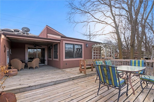 wooden terrace featuring a ceiling fan and outdoor dining space