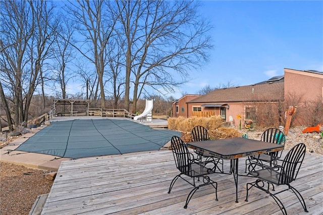 wooden terrace featuring a covered pool and outdoor dining area