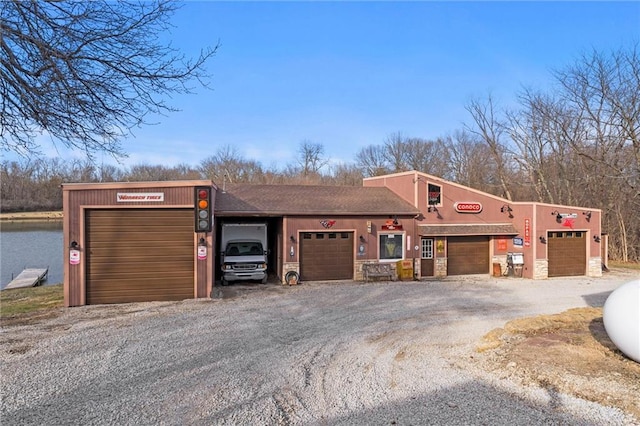 view of front of property with stone siding, driveway, an attached garage, and stucco siding