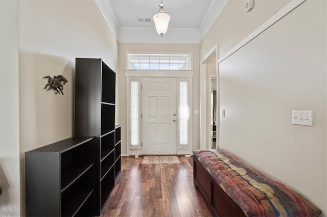 foyer featuring dark wood-style flooring, visible vents, and crown molding