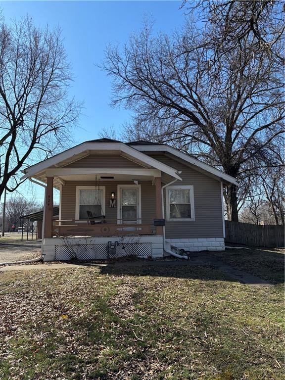 bungalow-style house with covered porch and fence