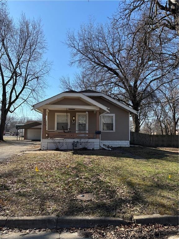 bungalow-style house featuring covered porch, a front yard, and fence