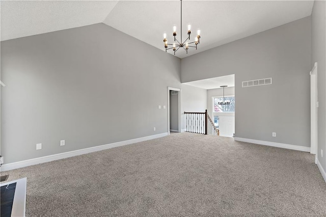 carpeted empty room with a chandelier, visible vents, high vaulted ceiling, and baseboards