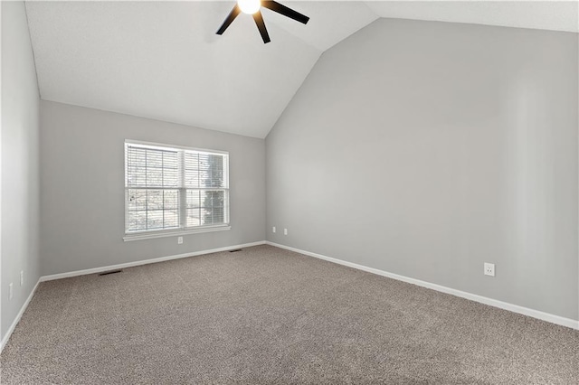 empty room with visible vents, carpet floors, baseboards, and vaulted ceiling