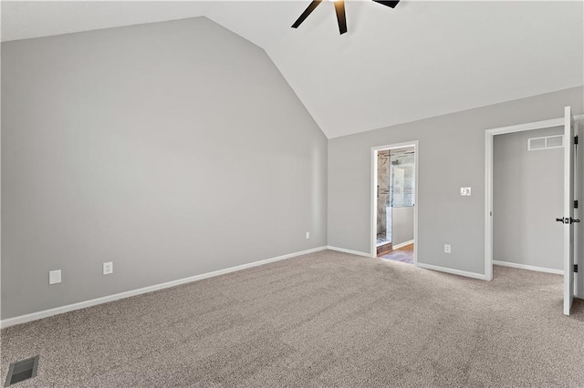 spare room featuring lofted ceiling, carpet flooring, baseboards, and visible vents