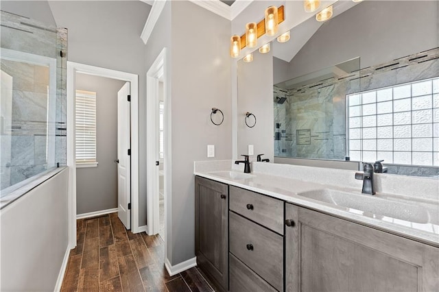 bathroom with a sink, wood tiled floor, a shower stall, and crown molding