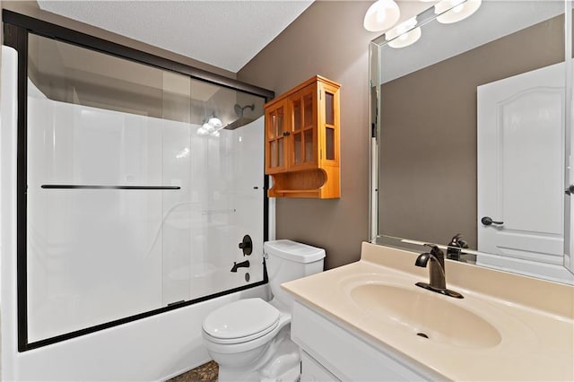 bathroom with a textured ceiling, toilet, vanity, and shower / bath combination with glass door