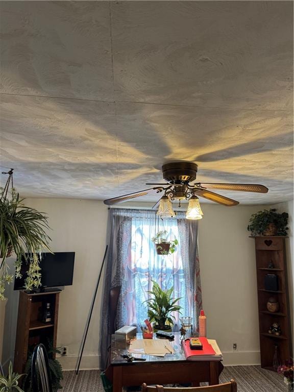 dining area with a ceiling fan and baseboards