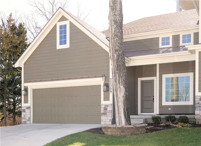 view of front of property with a shingled roof, stone siding, driveway, and a front lawn