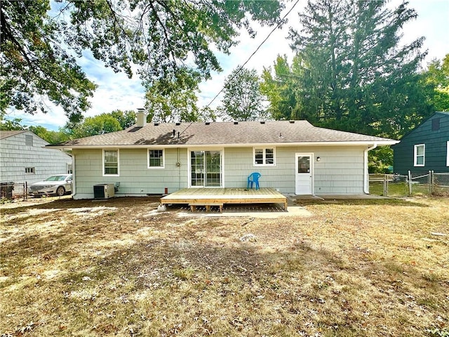 rear view of house with a chimney, central air condition unit, a gate, fence, and a wooden deck