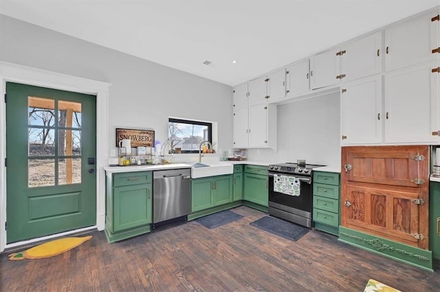 kitchen with light countertops, appliances with stainless steel finishes, white cabinets, a sink, and green cabinetry