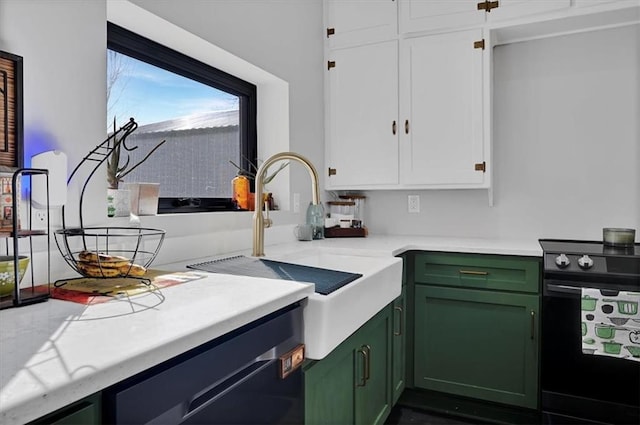 kitchen featuring electric range, a sink, white cabinets, light countertops, and green cabinetry